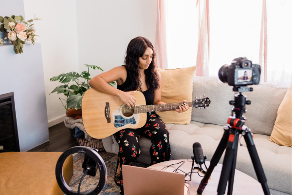 Person livestreaming playing guitar and singing