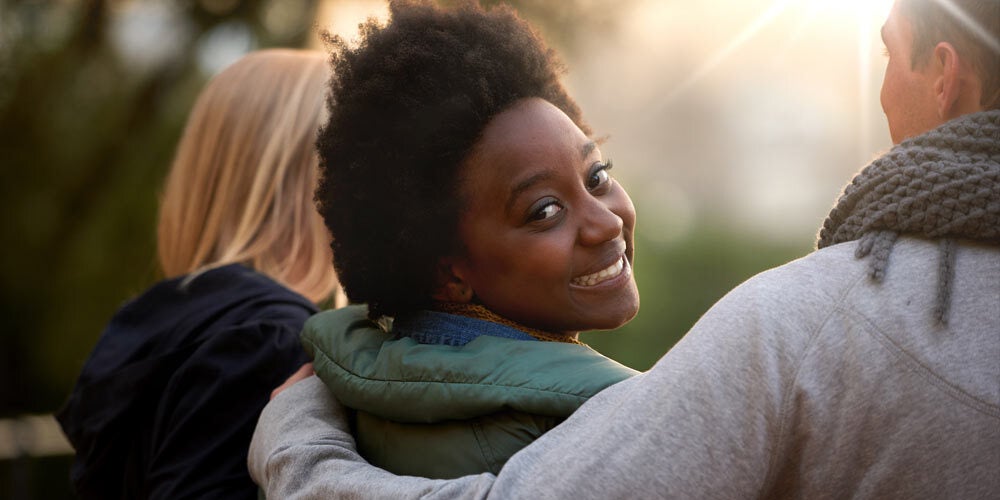 Three people, one woman looking over her shoulder at the camera