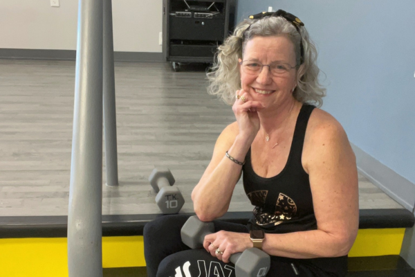 Tina smiling with weights at gym