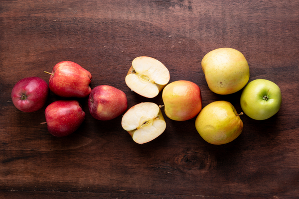 Three types of apples spread across a cutting board