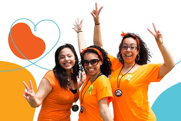 Three Kidney Walk participants cheering at a Walk event, surrounded by colorful graphics including a heart with a kidney bean