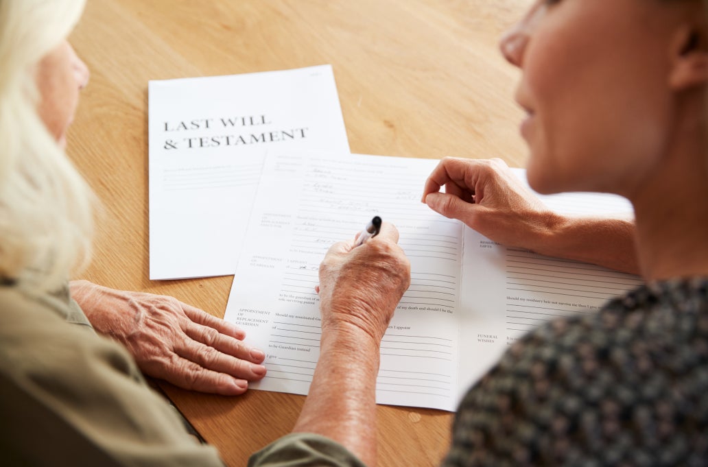 two people working on a will document at a desk