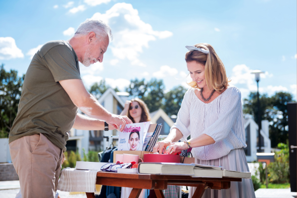 People going through a box at a yard sale