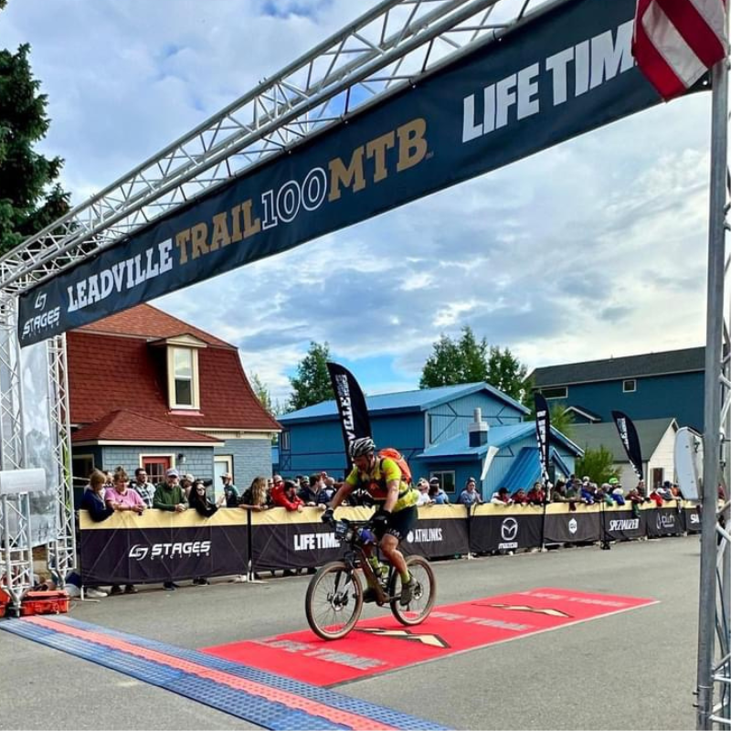 Zachary Sutton crossing finish line on his bike